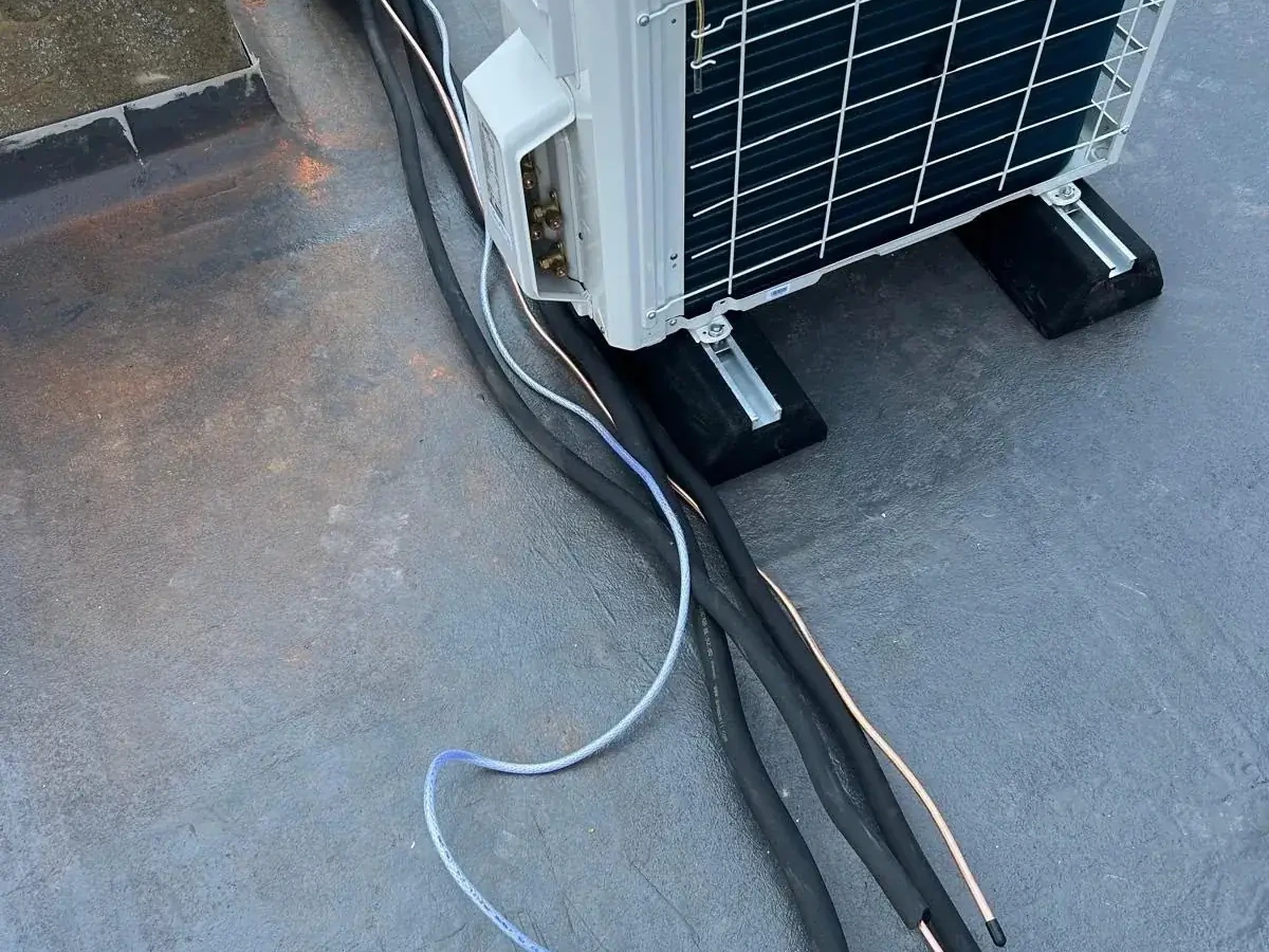 Engineer carrying out pressure checks on an outdoor air conditioning condenser for Perennia Climate Services