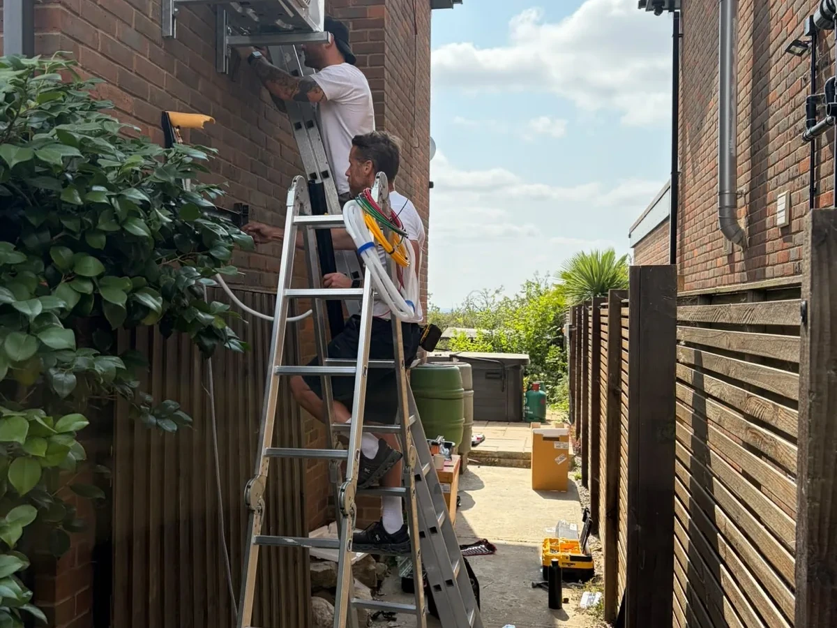 White wall-mounted air conditioning unit installed above a bedroom wardrobe by Perennia Climate Services