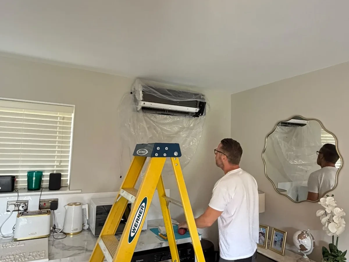 Perennia Climate Services engineer setting up an indoor air conditioning unit during installation