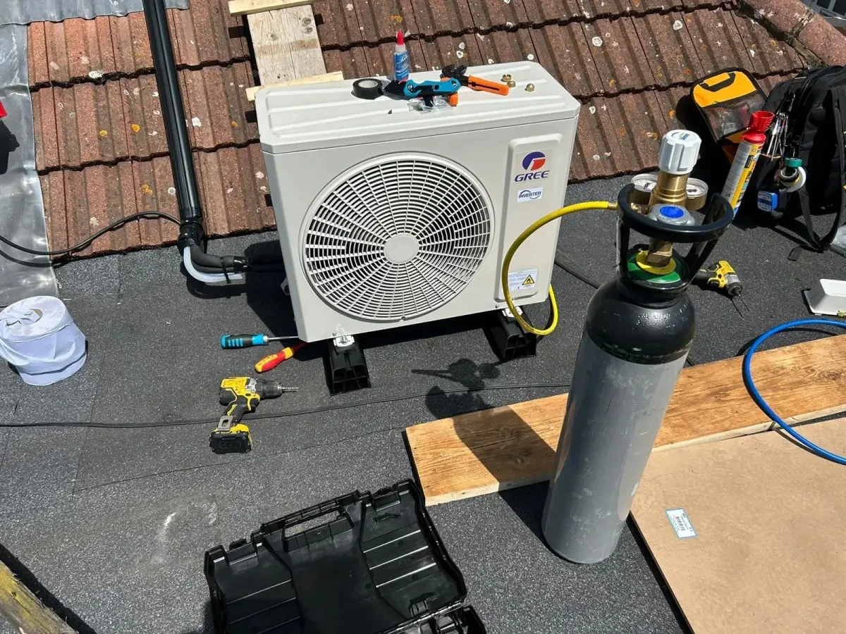 Perennia Climate Services engineer working on an outdoor air conditioning install beside an Essex home