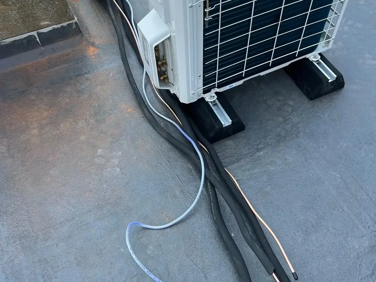 Outdoor air conditioning condenser with concealed pipework and tidy wall finish by Perennia Climate Services