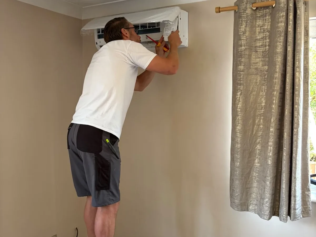 Ceiling cassette air conditioning grille installed flush in a white ceiling by Perennia Climate Services